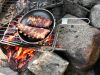 Côtelettes de porc sur bois brulant en camping