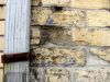 Gouttière avec attache rouillée sur mur de brique détruit