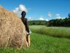 Mound of hay on fields green with beautiful woman in skirt