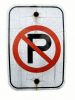 Sign prohibits parking, no parking, textured and cracked