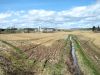 Paysage de terres à cultiver, drain et grange