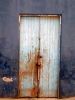 Old wooden door with rust color on old blue wall