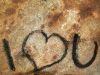 Written i love you on a rock with the ashes of a fire camping